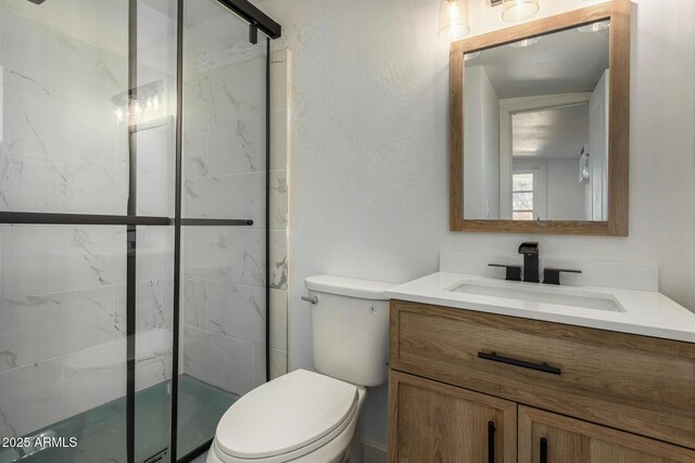 bathroom featuring vanity, an enclosed shower, and toilet