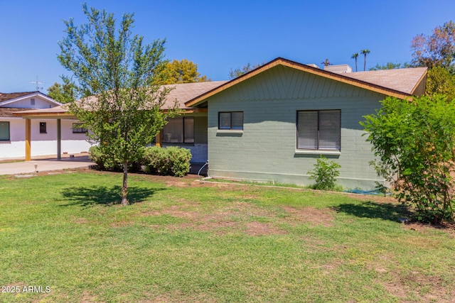 view of front facade with a front yard and a carport