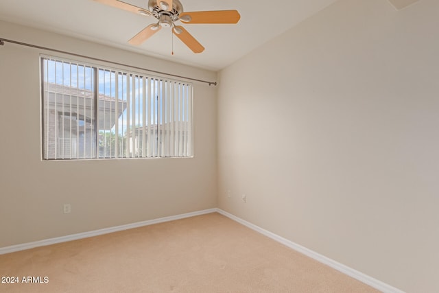 carpeted spare room featuring vaulted ceiling and ceiling fan