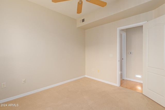 unfurnished room with visible vents, ceiling fan, light carpet, and baseboards