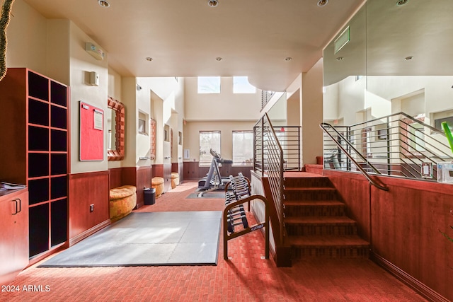 interior space featuring carpet flooring and a towering ceiling