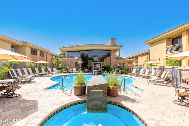 view of swimming pool featuring a patio area and a community hot tub