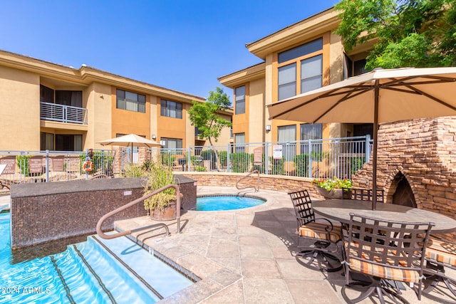 view of pool featuring a community hot tub and a patio area