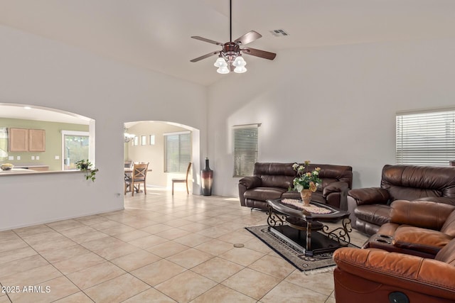 136 N 236th Ave, Buckeye, AZ 85396 - living room featuring light tile patterned floors, high vaulted ceiling, arched walkways, visible vents, and a ceiling fan