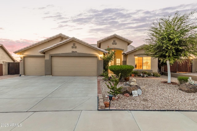136 N 236th Ave, Buckeye, AZ 85396 - view of front of house with a tile roof, concrete driveway, stucco siding, fence, and a garage