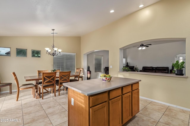 136 N 236th Ave, Buckeye, AZ 85396 - kitchen featuring vaulted ceiling, pendant lighting, light tile patterned floors, ceiling fan with notable chandelier, and arched walkways
