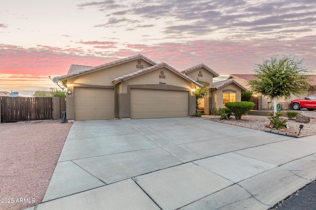 136 N 236th Ave, Buckeye, AZ 85396 - view of front of house with a tile roof, stucco siding, fence, driveway, and a garage