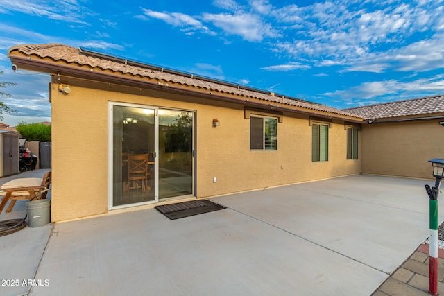 136 N 236th Ave, Buckeye, AZ 85396 - rear view of house featuring a tile roof, stucco siding, and a patio area