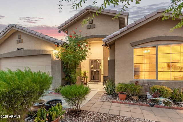136 N 236th Ave, Buckeye, AZ 85396 - view of front facade featuring a tile roof, stucco siding, and an attached garage