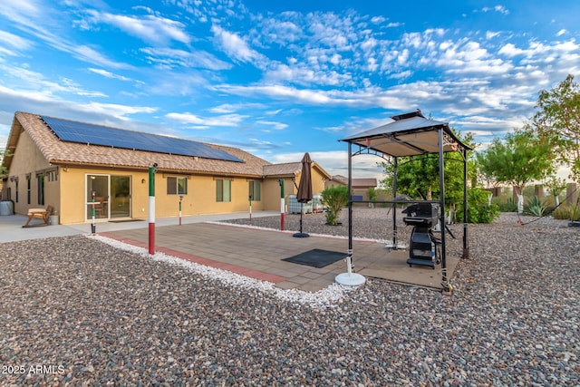 136 N 236th Ave, Buckeye, AZ 85396 - back of property with a tiled roof, roof mounted solar panels, a playground, a patio, and stucco siding