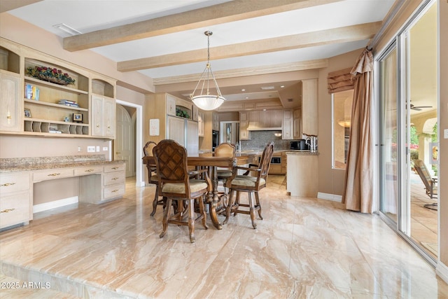 dining space with built in desk and beam ceiling