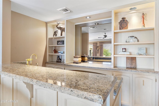 kitchen with light stone countertops and ceiling fan