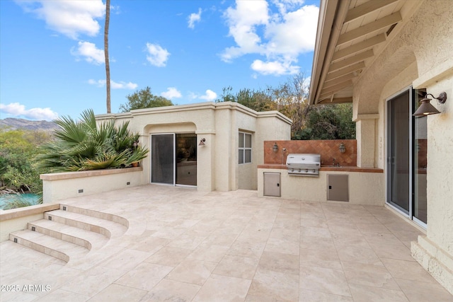 view of patio / terrace featuring area for grilling, a grill, and a mountain view