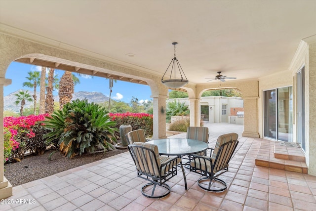 view of patio with ceiling fan, an outdoor kitchen, and a mountain view