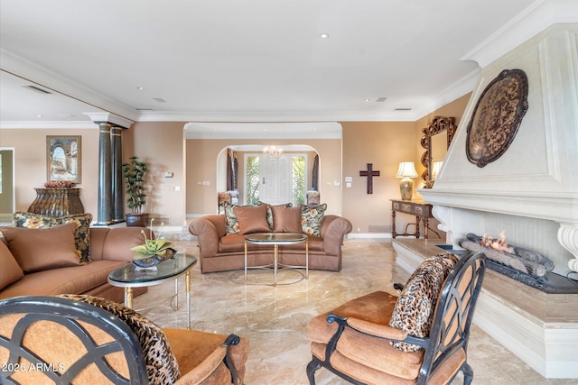 living room with ornamental molding, a chandelier, and decorative columns