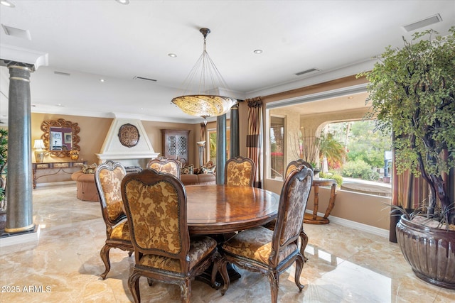 dining area with ornamental molding and decorative columns