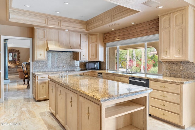 kitchen featuring decorative backsplash, a center island, a raised ceiling, light stone countertops, and light brown cabinets