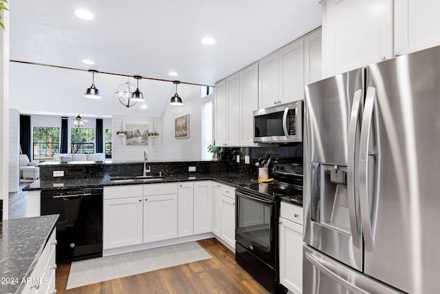 kitchen featuring black appliances, dark stone countertops, white cabinetry, and hanging light fixtures