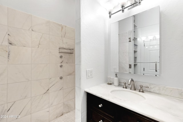 bathroom with vanity and a tile shower