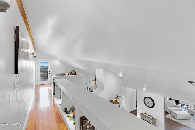 hallway featuring vaulted ceiling and hardwood / wood-style flooring