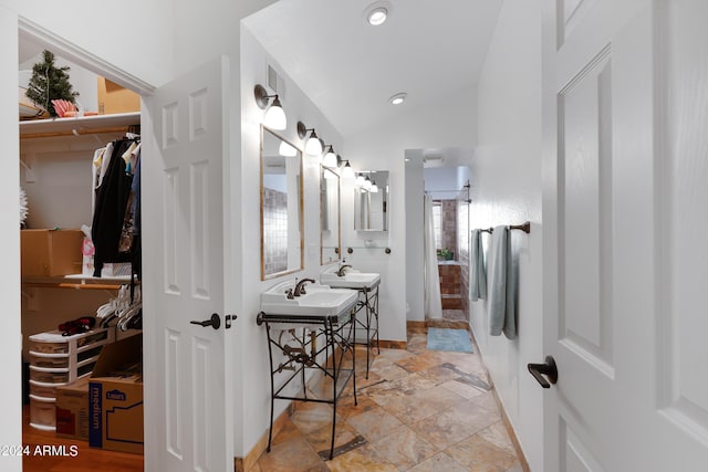 bathroom with sink, vaulted ceiling, and a shower