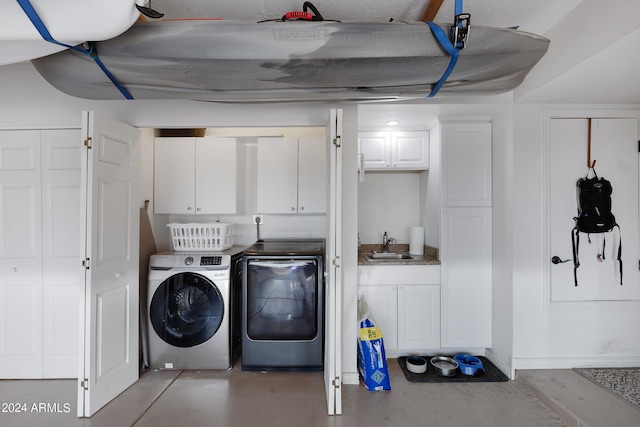 laundry room with sink, washer and clothes dryer, and cabinets