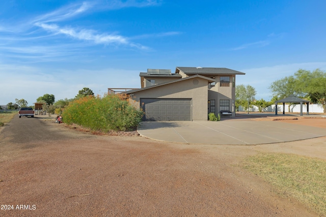 view of side of property with a garage and a gazebo