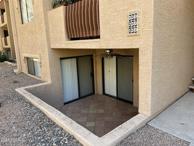 view of exterior entry featuring ceiling fan