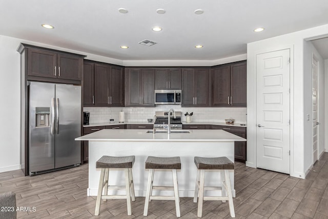 kitchen featuring appliances with stainless steel finishes, sink, a breakfast bar area, and a kitchen island with sink