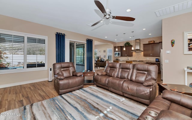 living room featuring sink, a wealth of natural light, ceiling fan, and light hardwood / wood-style flooring