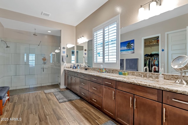 bathroom with vanity, wood-type flooring, and a shower with door