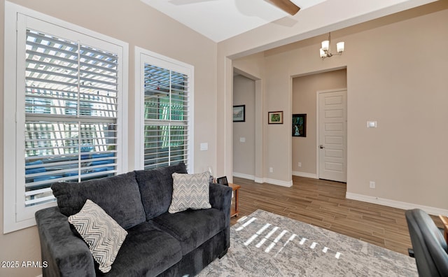 living room featuring wood-type flooring and ceiling fan with notable chandelier