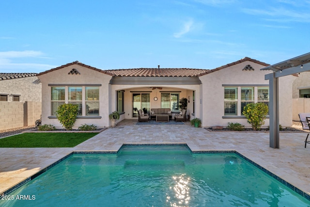 back of property with ceiling fan, an outdoor living space, and a patio area