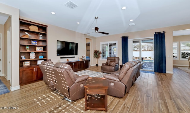 living room featuring ceiling fan, vaulted ceiling, and light wood-type flooring