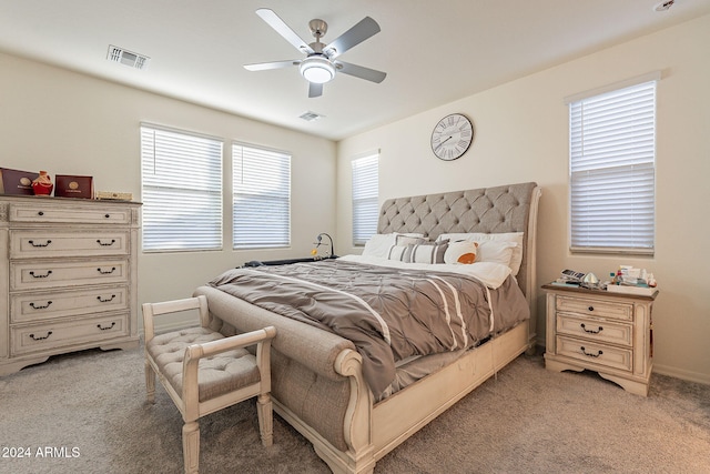 carpeted bedroom featuring multiple windows and ceiling fan