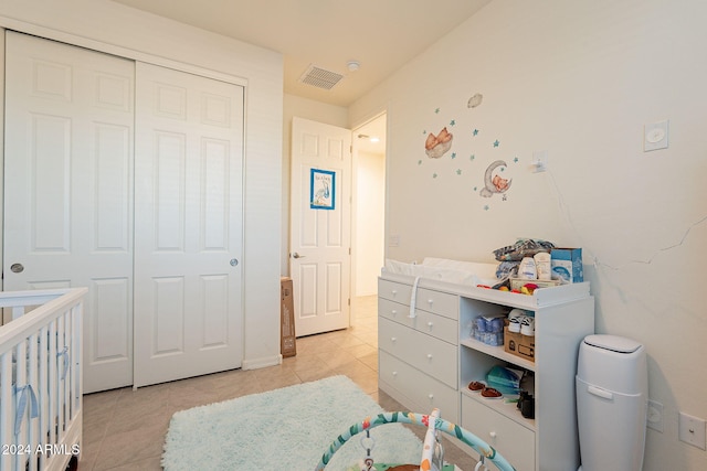 tiled bedroom with a nursery area and a closet