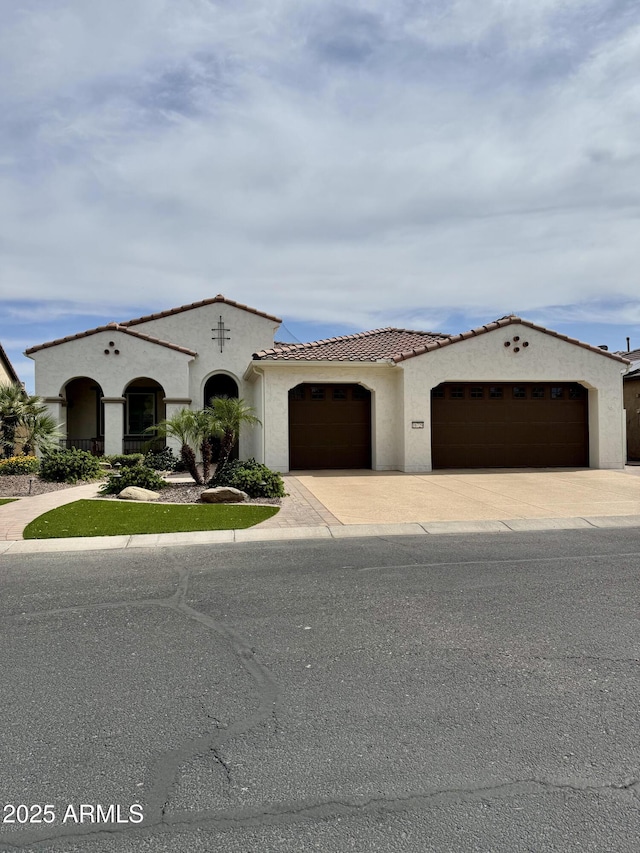 16729 W Alvarado Dr, Goodyear, AZ 85395 - mediterranean / spanish house featuring a garage, concrete driveway, stucco siding, and a tiled roof