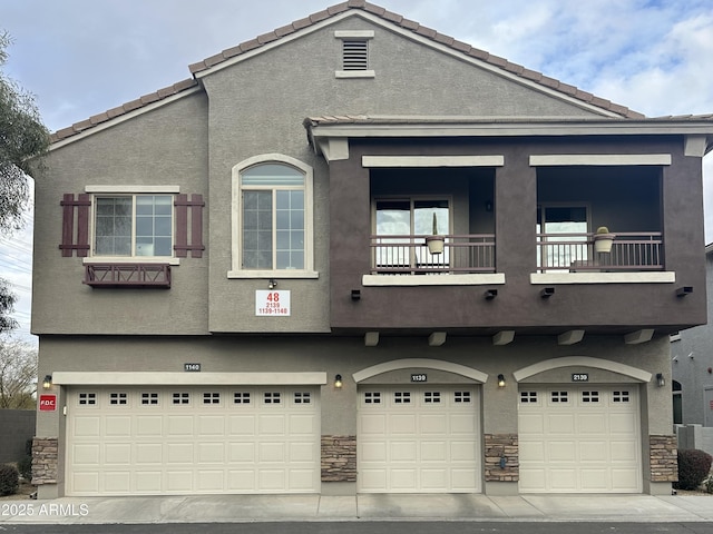 2150 W Alameda Rd Unit 2139, Phoenix, AZ 85085 - view of front of home with a garage, stucco siding, a balcony, and stone siding