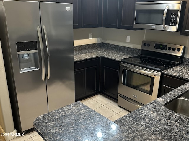 2150 W Alameda Rd Unit 2139, Phoenix, AZ 85085 - kitchen with stainless steel appliances, light tile patterned floors, dark stone counters, dark cabinetry, and a sink