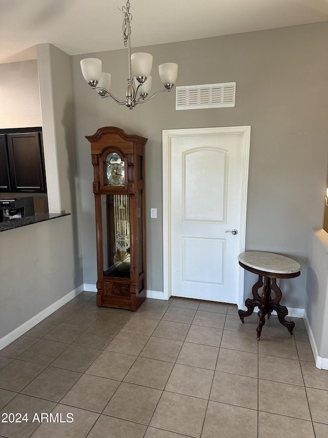 foyer featuring light tile patterned flooring and a chandelier