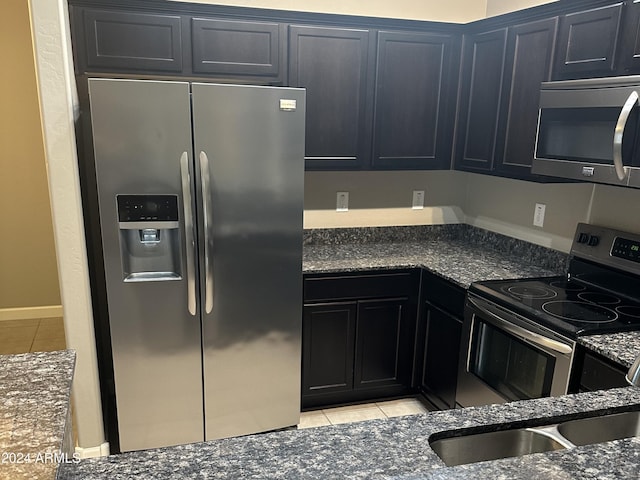 2150 W Alameda Rd Unit 2139, Phoenix, AZ 85085 - kitchen featuring stainless steel appliances, light tile patterned floors, dark stone counters, and dark cabinets