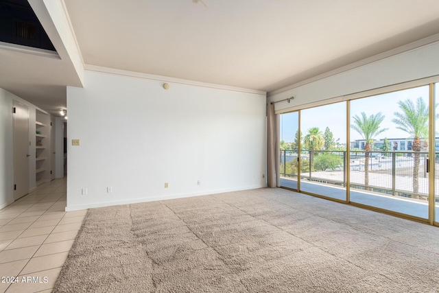 spare room featuring light tile patterned floors and crown molding