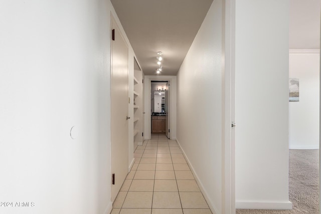 corridor with light tile patterned floors and built in shelves