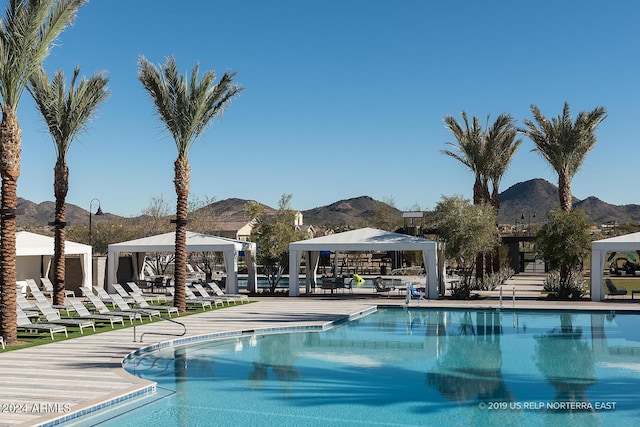 view of swimming pool featuring a mountain view, a gazebo, and a patio area