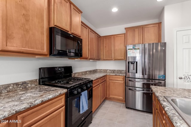 kitchen featuring light tile patterned floors, brown cabinets, light stone countertops, black appliances, and recessed lighting