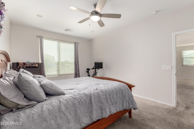 bedroom with carpet floors, baseboards, multiple windows, and visible vents