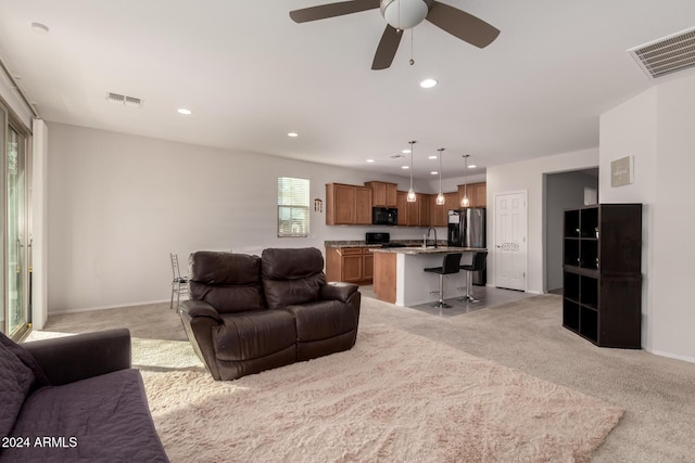 living area featuring recessed lighting, visible vents, and light carpet