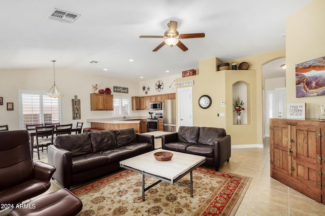 living room featuring ceiling fan, lofted ceiling, sink, and light tile patterned floors