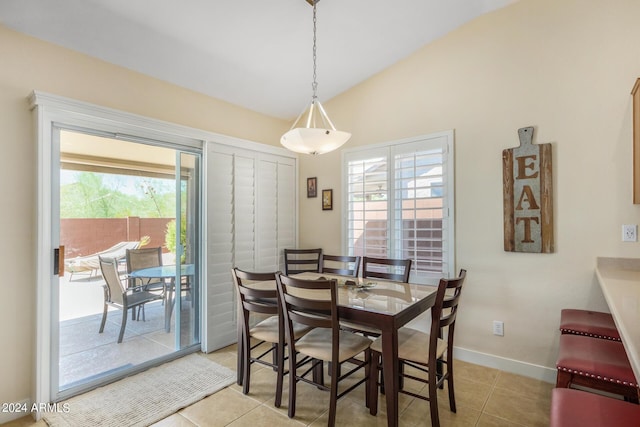 tiled dining area featuring lofted ceiling