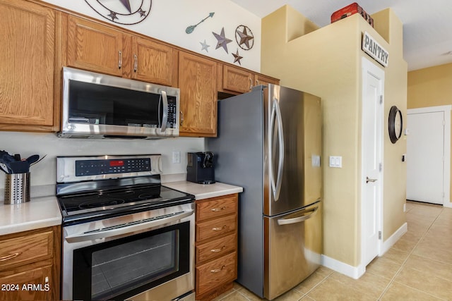 kitchen with light tile patterned flooring and appliances with stainless steel finishes